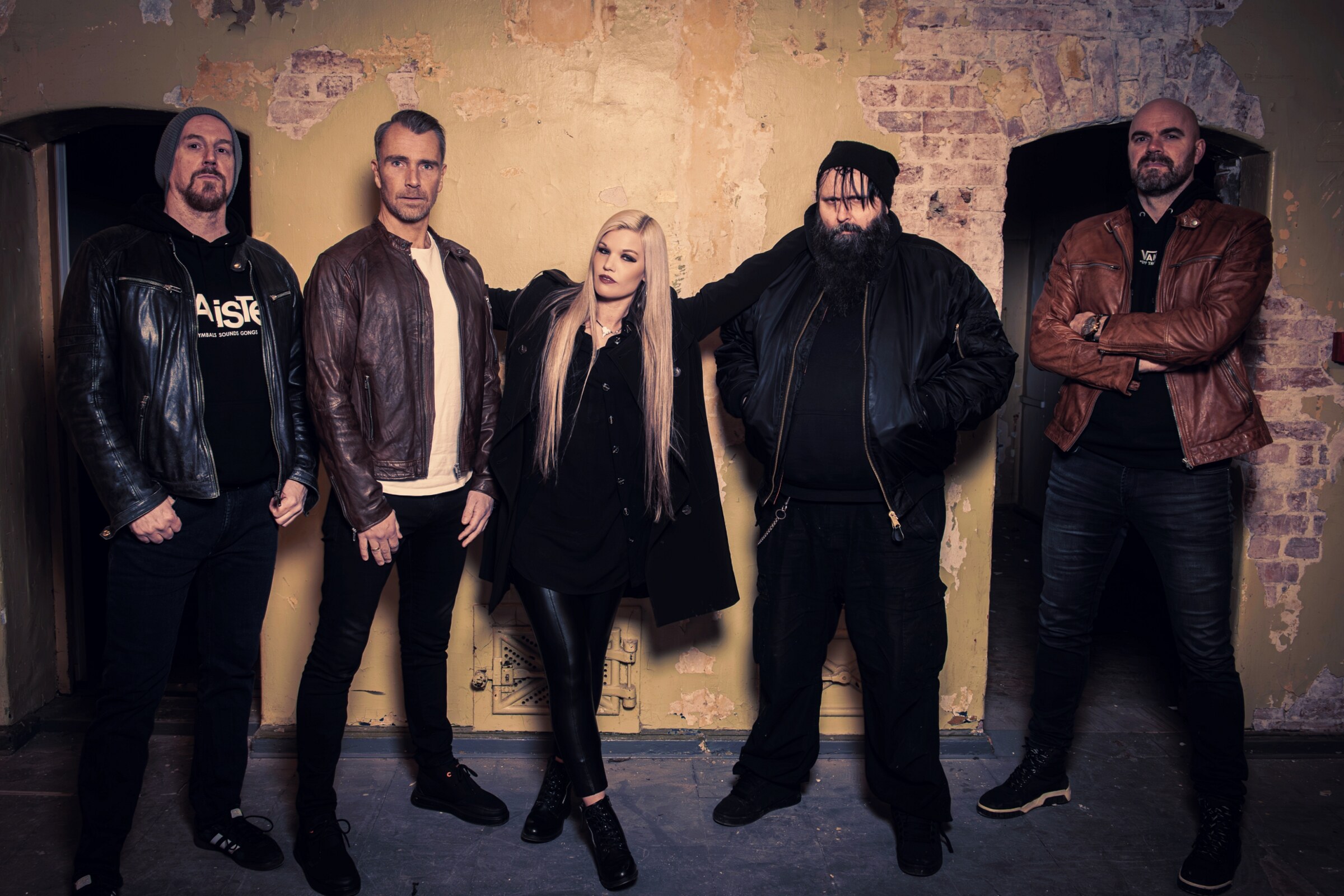 The five members lined up against a weathered vault wall — official promo shot for "Down In Flames". Photo: Kim Söderström